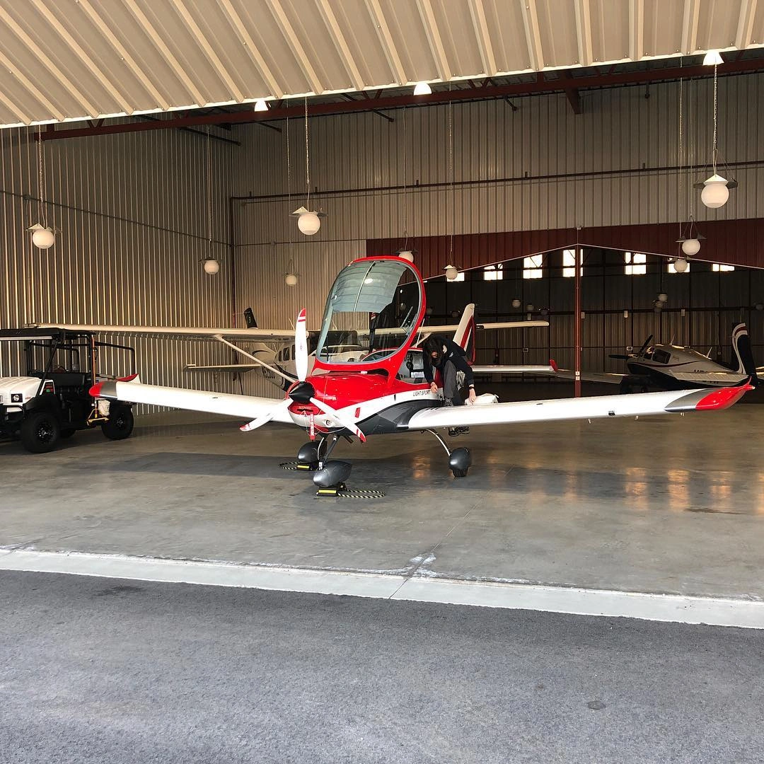 Red training aircraft inside the hangar