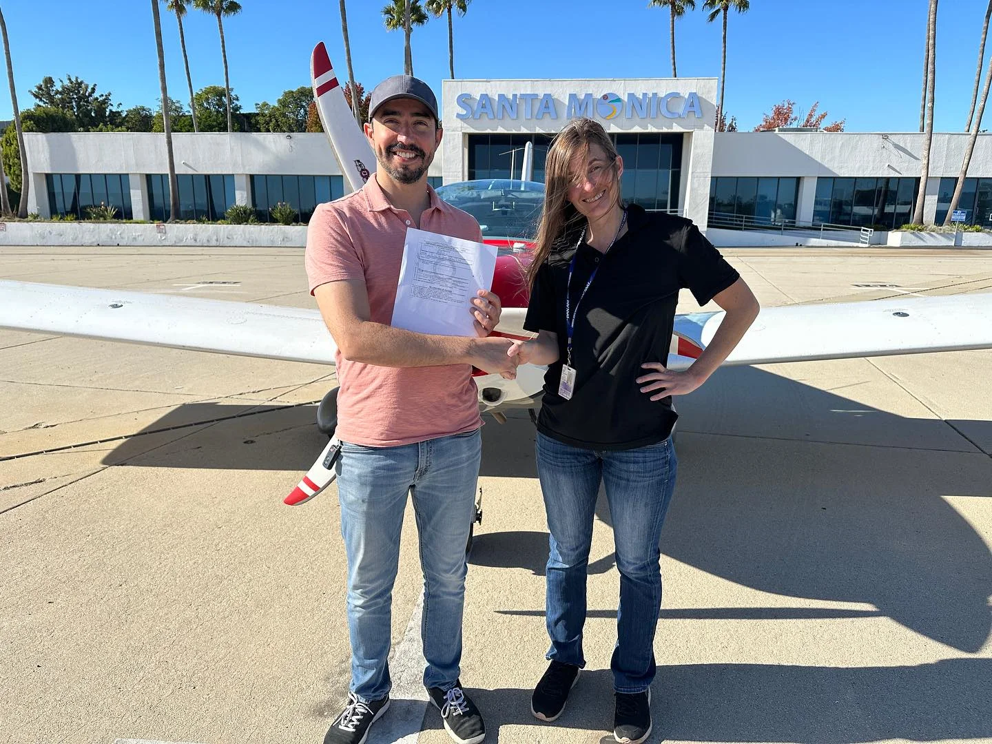 Instructor and student standing in front of an aircraft