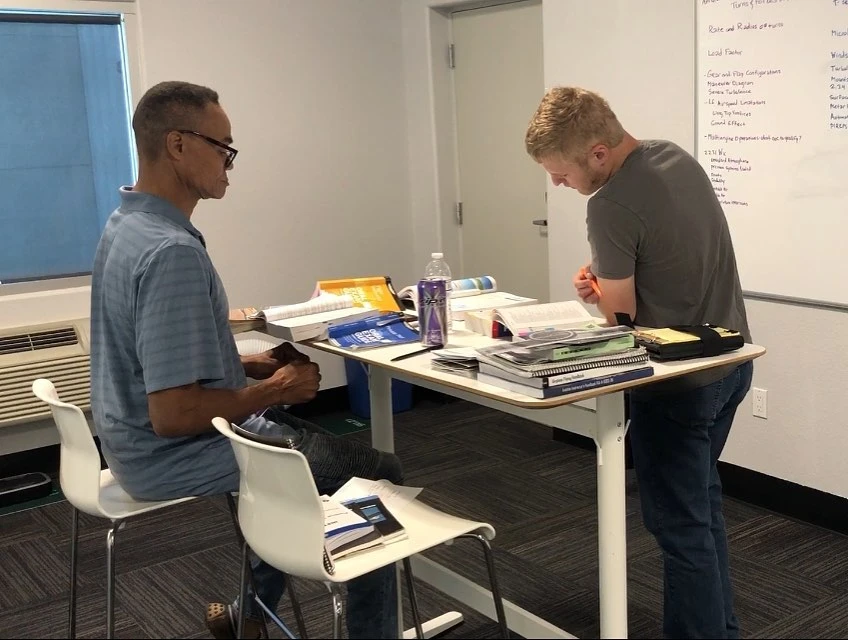 Student studying with an instructor at a table